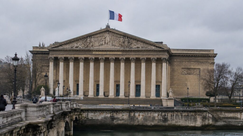 De Franse vlag wappert boven het Palais Bourbon, zetel van de Assemblée nationale in Parijs, op een bewolkte middag