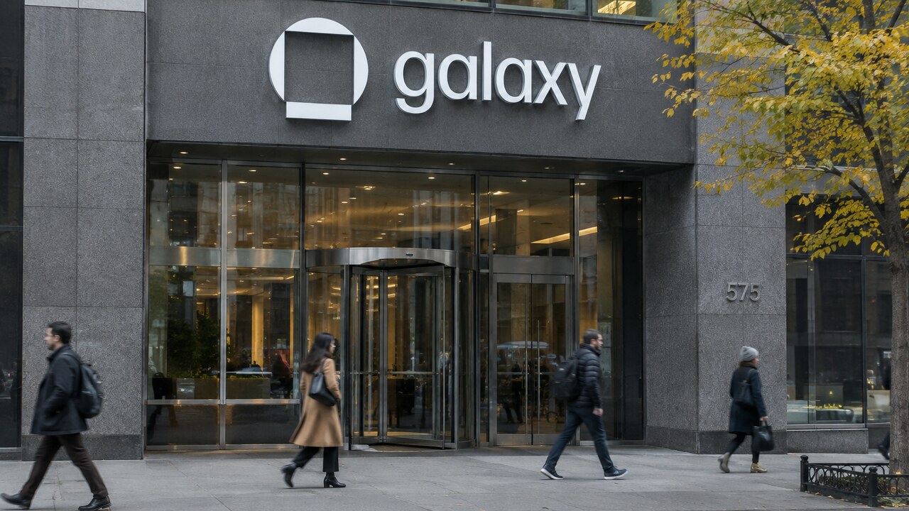 Gevel van een kantoortoren in New York met een groot Galaxy-logo boven de ingang op een bewolkte herfstmiddag