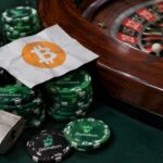 Roulettetafel met Gamdom-fiches, een opengeknipt hangslot en een losgeldbriefje met het Bitcoin-symbool