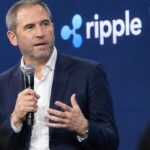 Ripple-CEO Brad Garlinghouse spreekt op het podium van de Swell-conferentie met het Ripple-logo op de achtergrond