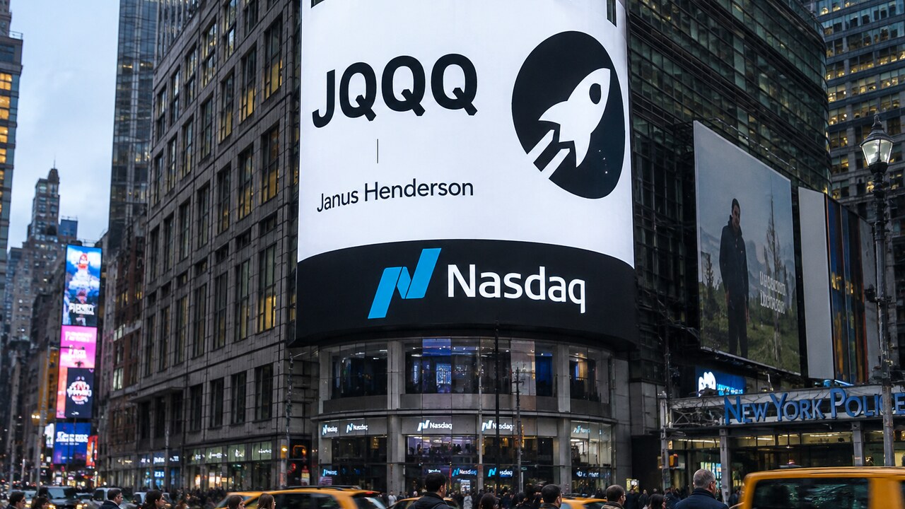 Het gebogen Nasdaq-scherm op Times Square toont JQQQ met de logo's van Stellar en Janus Henderson boven voorbijgangers