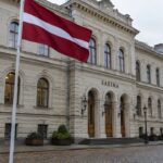 De Letse vlag wappert voor het parlementsgebouw van de Saeima in de oude binnenstad van Riga