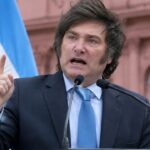 Javier Milei spreekt fel bij een spreekgestoelte voor de Casa Rosada in Buenos Aires met Argentijnse vlaggen