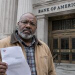 Ondernemer met een geopende bankbrief op de trappen voor de stenen gevel van een grote Amerikaanse bank