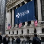 Klassiek bankgebouw met zuilen aan Wall Street met een groot Ripple-spandoek, voorbijgangers op de stoep
