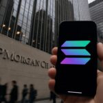 Hand met smartphone met het Solana-logo voor het hoofdkantoor van JPMorgan Chase in New York