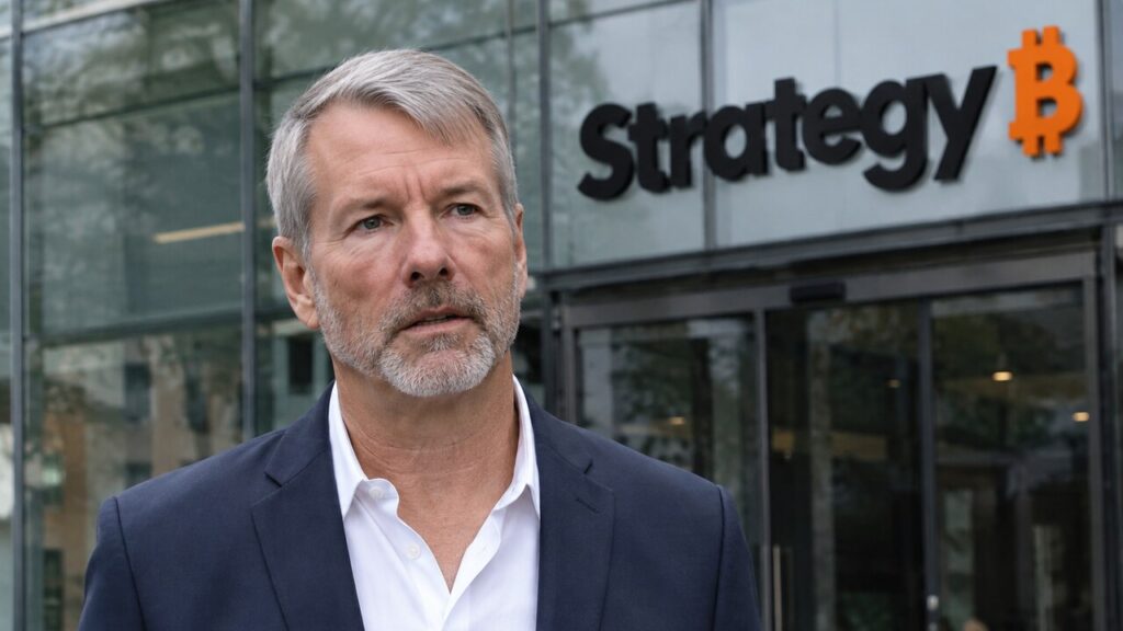 Michael Saylor in donker pak voor de ingang van een gebouw met het Strategy-logo op de gevel