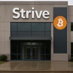 Gevel van een kantoorgebouw met groot Strive-logo en een banner met het Bitcoin-symbool bij de ingang
