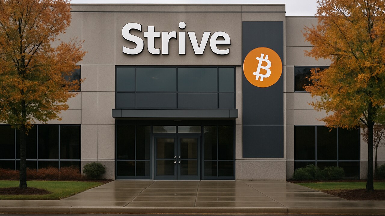 Gevel van een kantoorgebouw met groot Strive-logo en een banner met het Bitcoin-symbool bij de ingang