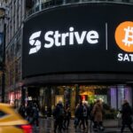 Groot digitaal reclamescherm in een stadsstraat met het Strive-logo, een Bitcoin-symbool en de ticker SATA, voorbijgangers in de schemering