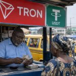 Druk geldwisselkantoor op een markt in Lagos met een groot TRON-logo en een USDT-bord boven de toonbank