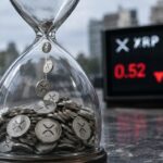 Zandloper gevuld met zilveren munten met het XRP-logo, met op de achtergrond een wazig scherm met rode koerscijfers