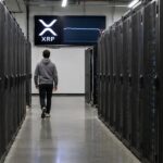 Gangpad in een AI-datacenter met serverkasten en aan het eind een scherm met het XRP-logo en een vlakke koersgrafiek