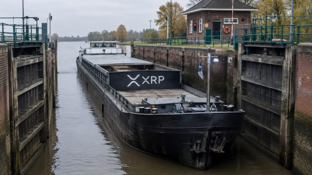 Vrachtschip met groot XRP-logo wacht in een Nederlandse sluis tussen twee gesloten sluisdeuren