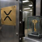 Kluisdeur met XRP Ledger-logo, een hoofdsleutel in een glazen kastje en kleinere sleutels aan haakjes