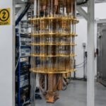 Quantumcomputer met gouden koelconstructie in een laboratorium, met een Zcash-logo op het frame en een zware stalen deur op de achtergrond