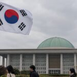 Zuid-Koreaanse vlag wappert voor het parlementsgebouw met groene koepel in Seoul op een bewolkte herfstdag